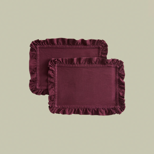 Two burgundy linen placemats with ruffle edge