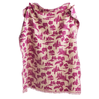 A throw blanket with outdoor pattern containing tree motifs in a magenta print