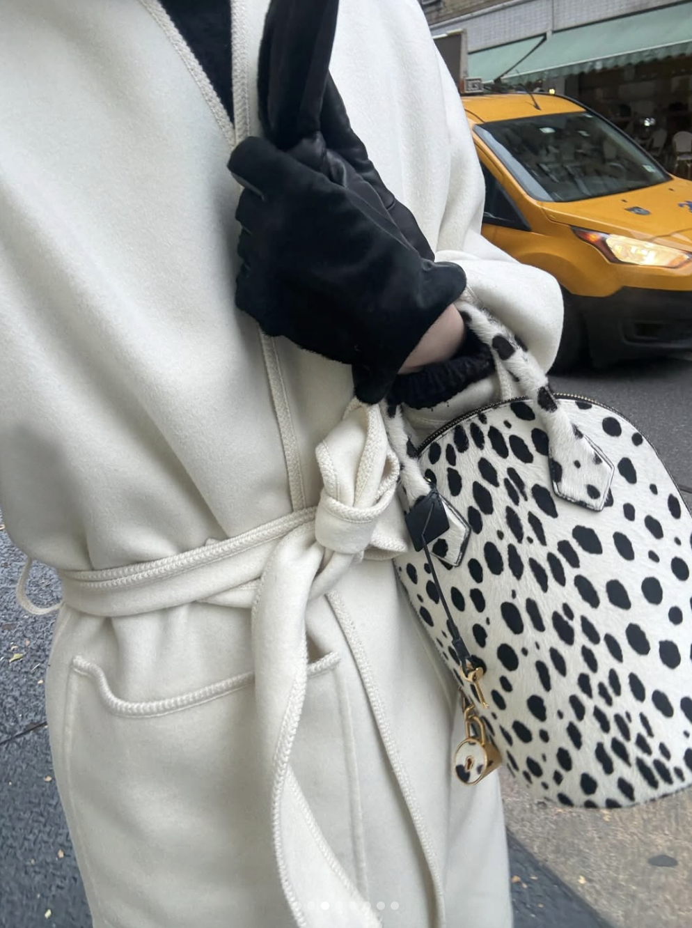 woman in white coat with dalmation bag