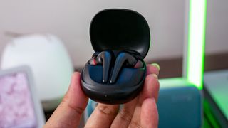 More Aero earbuds with a charging case in the hand
