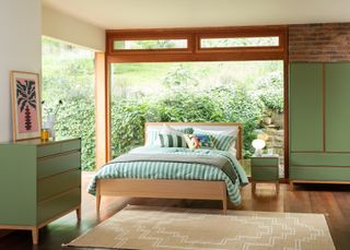 An olive green bedroom with neatly made bed