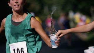 Runner taking cup of water during race