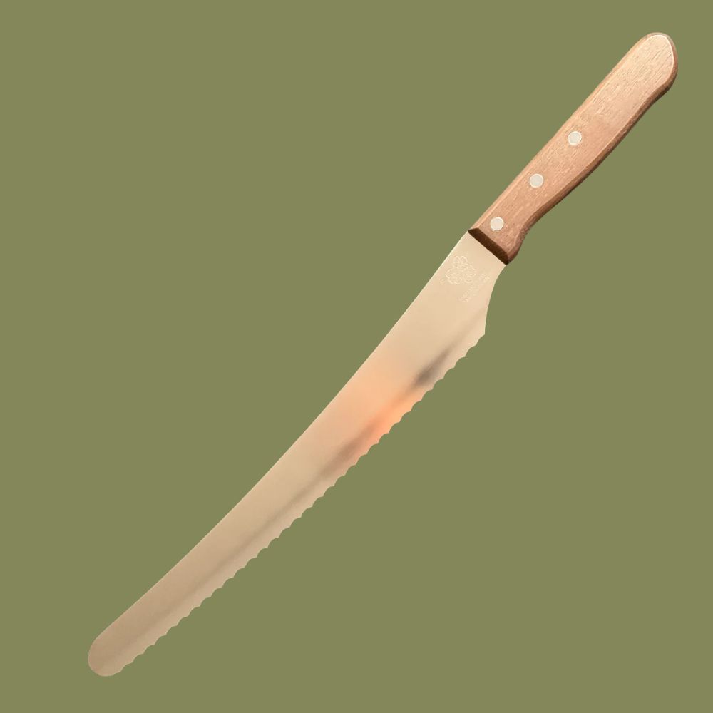 A silver bread knife with wooden handle sitting against a dark green background.