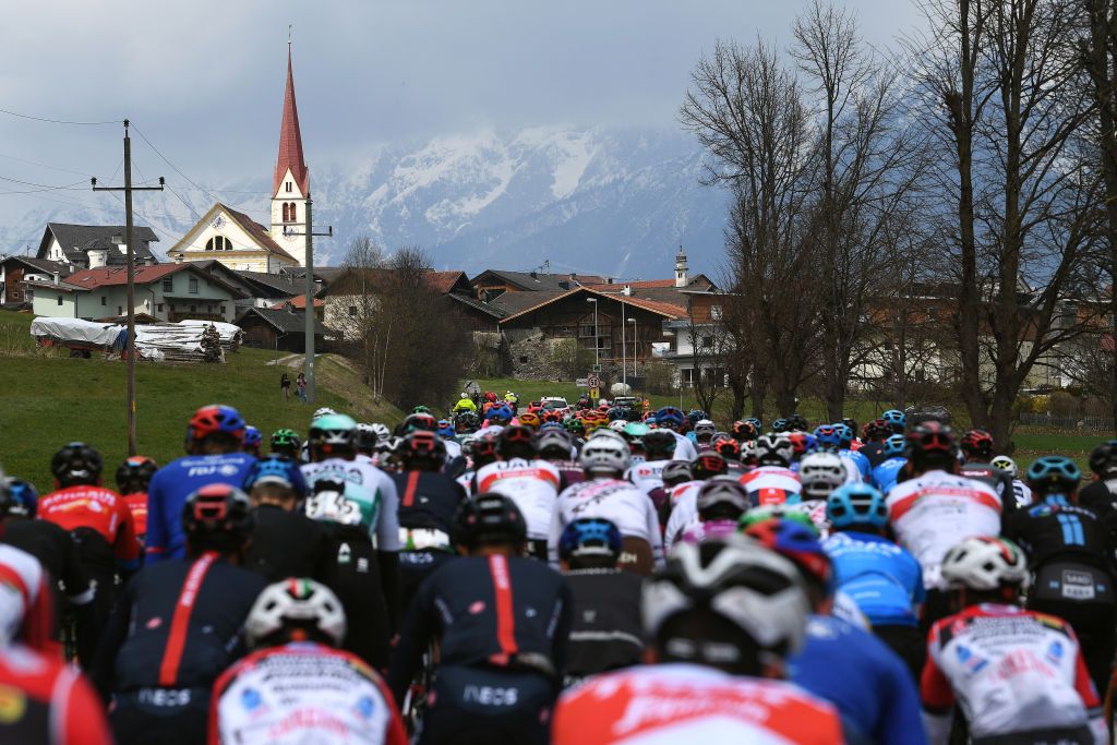 FEICHTEN IM KAUNERTAL AUSTRIA APRIL 20 The Peloton passing through Flaurling Village during the 44th Tour of the Alps 2021 Stage 2 a 1215km stage from Innsbruck to Feichten im Kaunertal 1291m Landscape Margaret the Virgin Church Mountains Snow TourofTheAlps TouroftheAlps on April 20 2021 in Feichten im Kaunertal Austria Photo by Tim de WaeleGetty Images