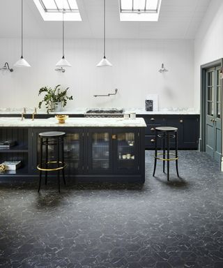 A kitchen with a vinyl floor, emulating black marble hexagonal tiles.