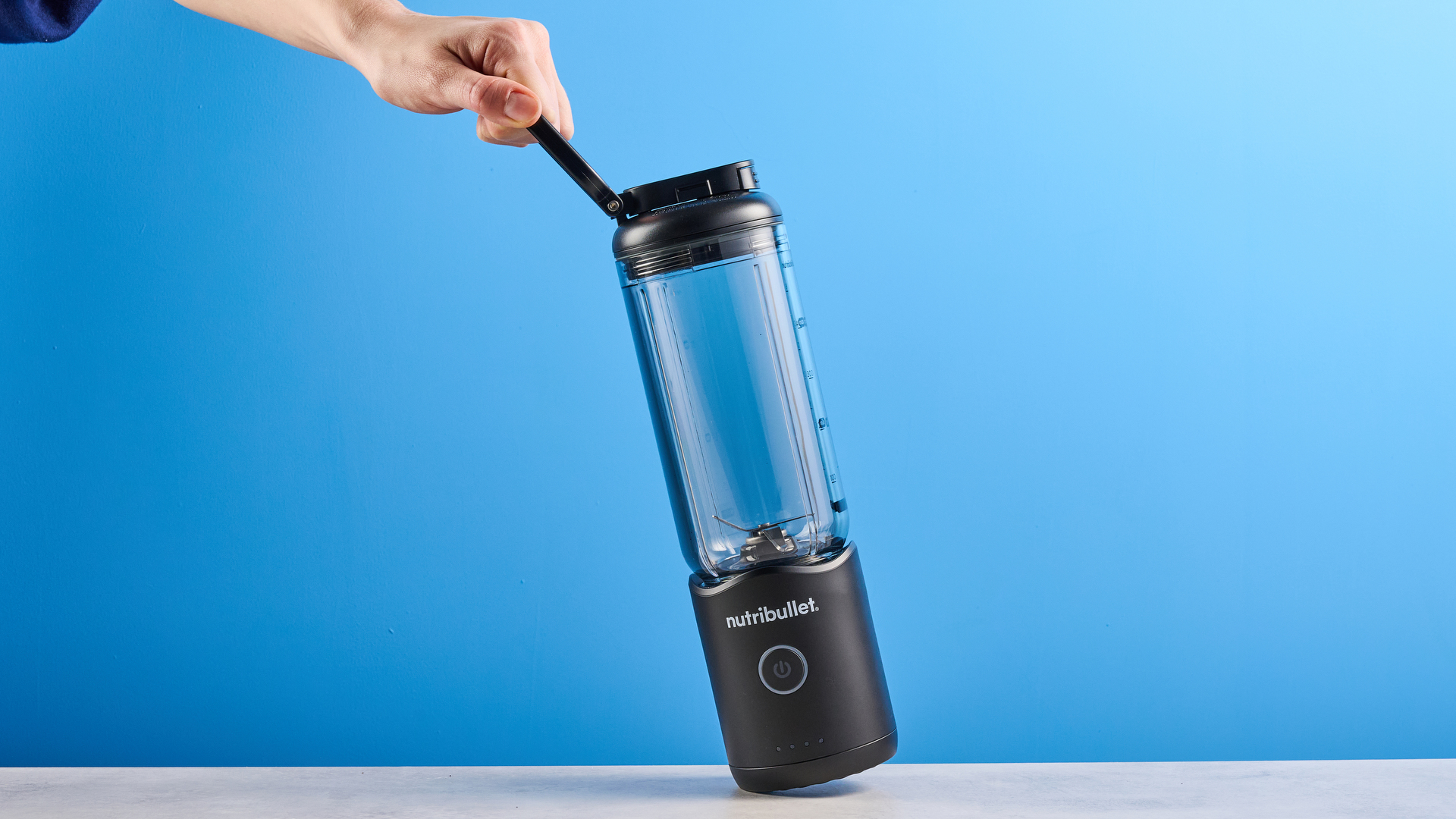 Nutribullet Flex blender photographed on a blue background