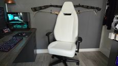 The Noblechairs Legend gaming chair on a wooden floor in front of a grey wall