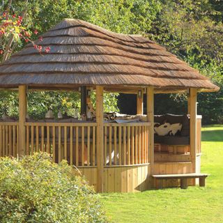 thatched gazebo style building in garden