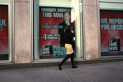 A woman walks by an ad for Bill O'Reilly's television show.