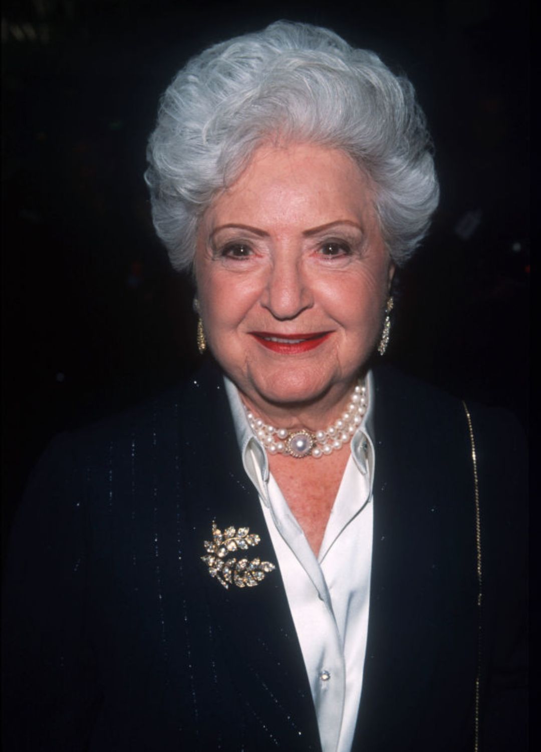 Ruth Handler wearing a pearl choker and bejewelled brooch