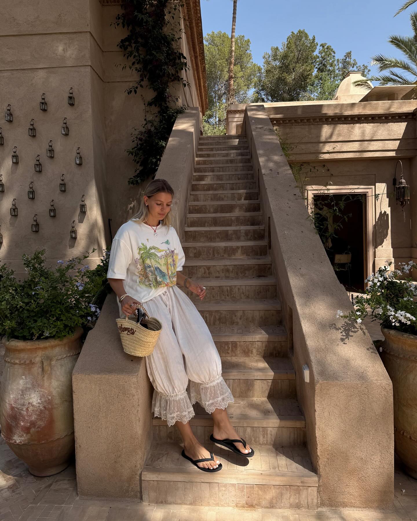 @holliemercedes wears a pair of bloomer trousers with lace trims with a graphic T-shirt