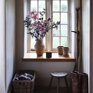 cottage hallway with rustic interior with flowers in vase on windowsill