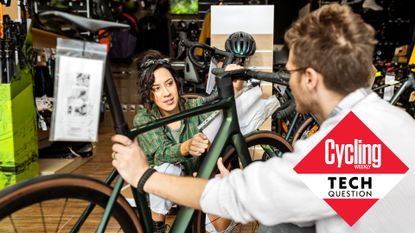 Bike shop employee shows customer a modern road bike 