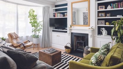 Living room with glass storage cabinet next to white armchair.