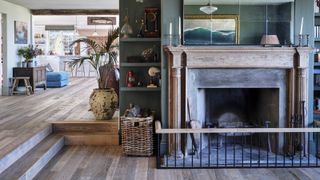 dark blue living room with large fireplace and view to open plan kitchen