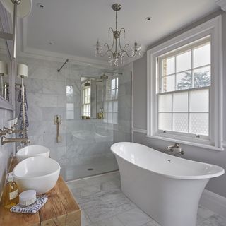 marble tiled bathroom with bathtub and washbasin