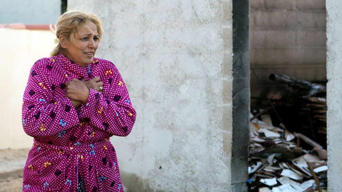 A woman looks at the remains of her house following fires in the Vitrolles region, north of Marseille