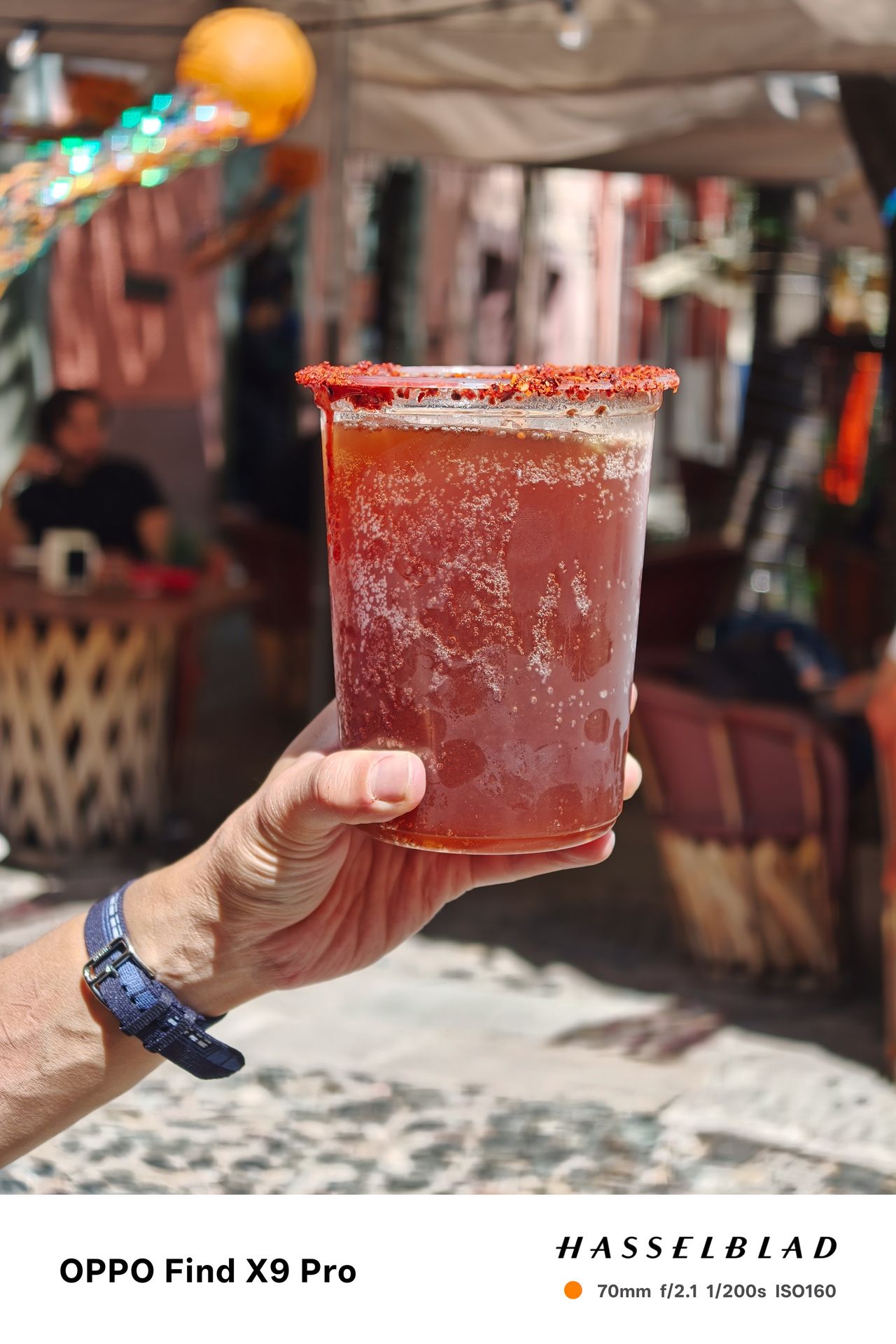 A person holding up a large cocktail drink