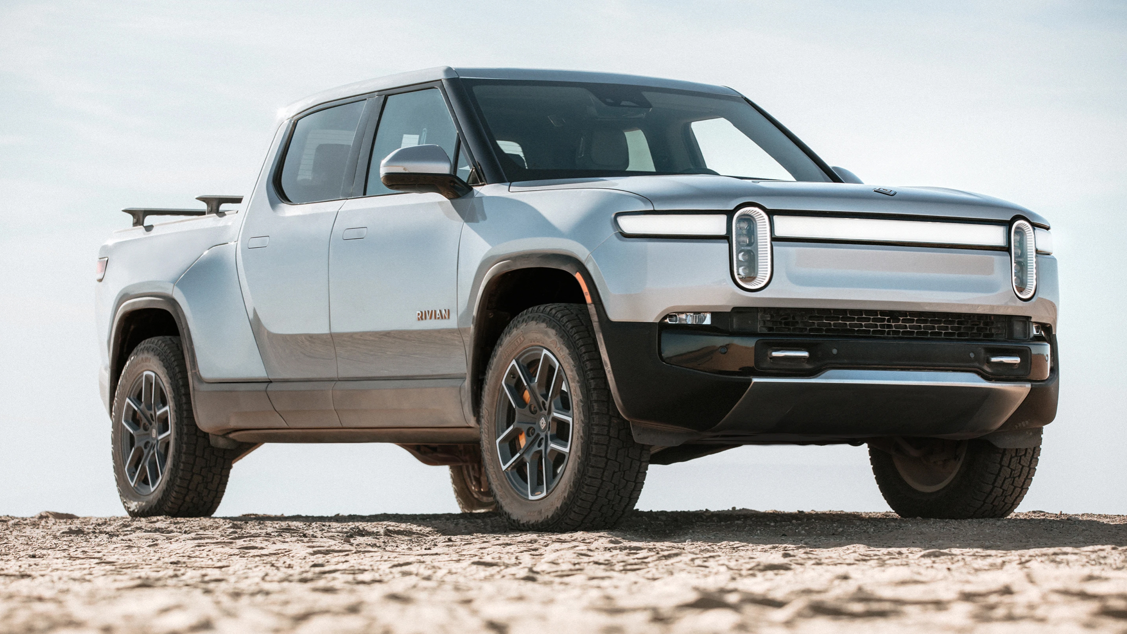 The Rivian R1T parked on a rocky outcrop
