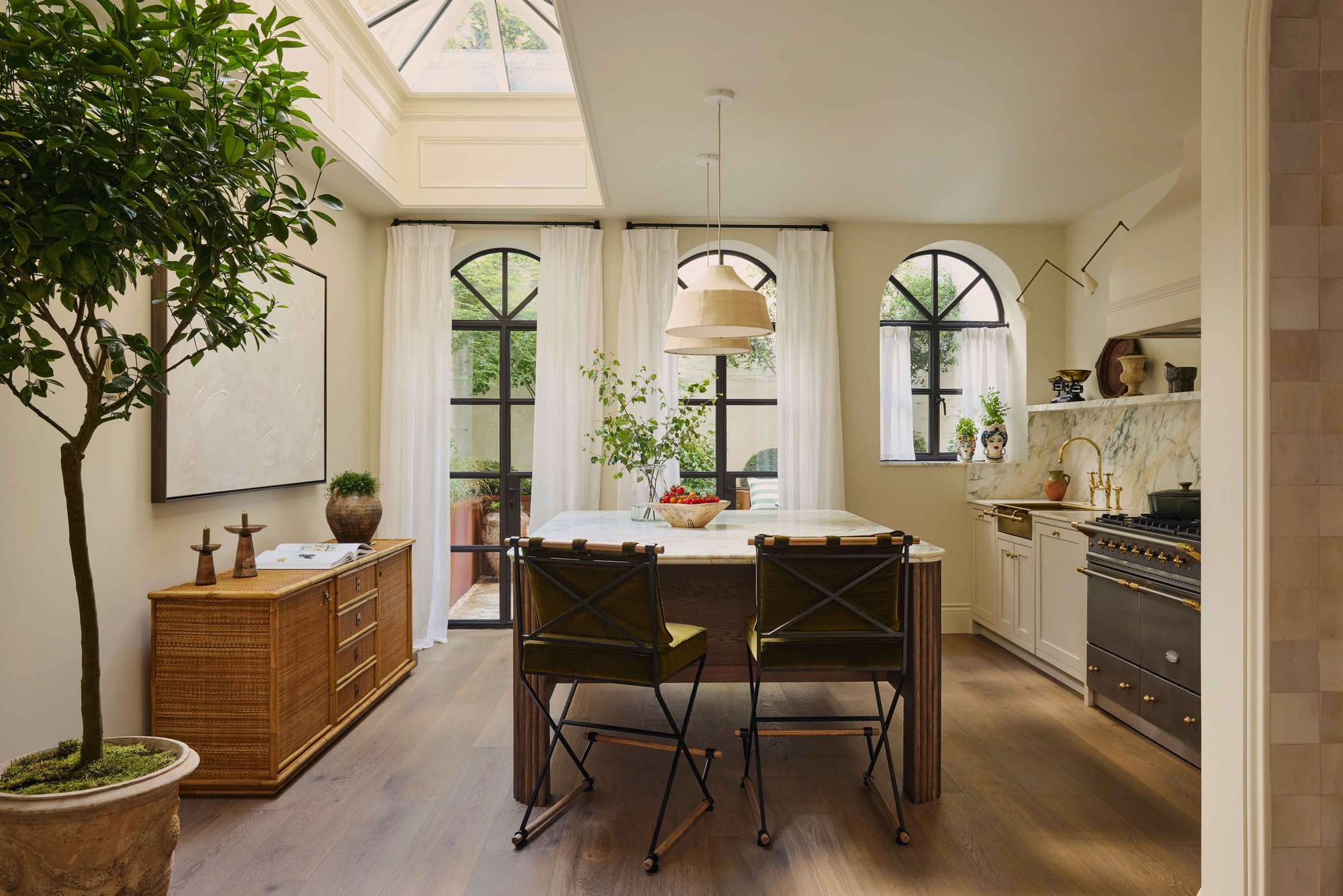 a neutral toned kitchen with a large island bench and a bowl of cherry tomatoes