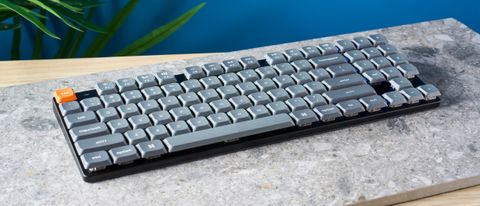 A black Keychron K13 Max wireless keyboard with gray and orange keycaps