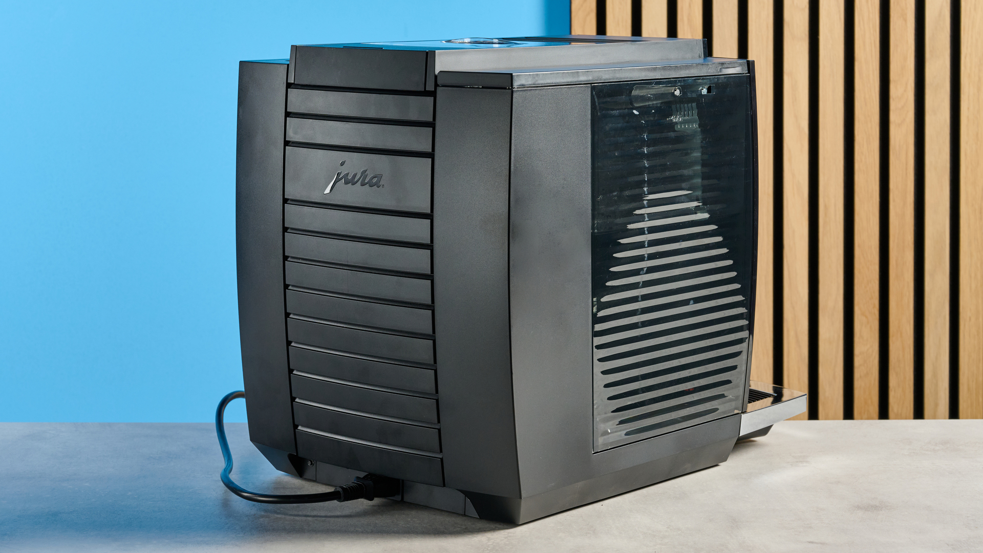 the jura E8 automatic coffee machine in piano black with a 64 ounce water tank, screen, and jura logo on the front