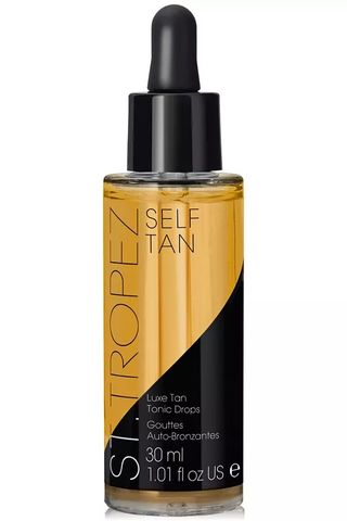 A bottle of St. Tropez self tan drops set against a white background.