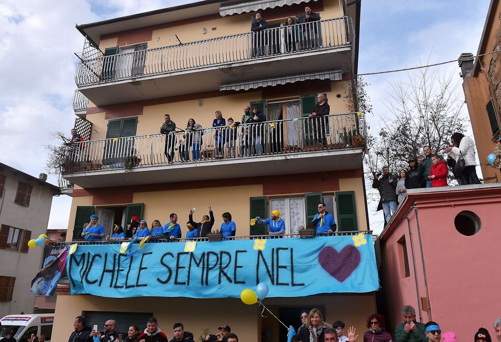 Filottrano spectators stand along a banner honouring Michele Scarponi