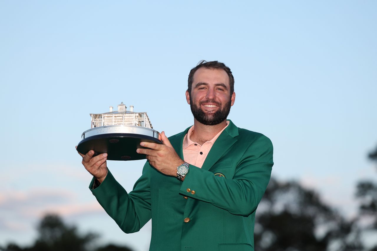 Scottie Scheffler holds the Masters trophy and wears the Green Jacket