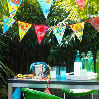 garden with multicoloured bunting and rectangular black table with blue tableware