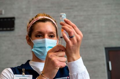 A nurse prepares a COVID-19 vaccine in Massachusetts.