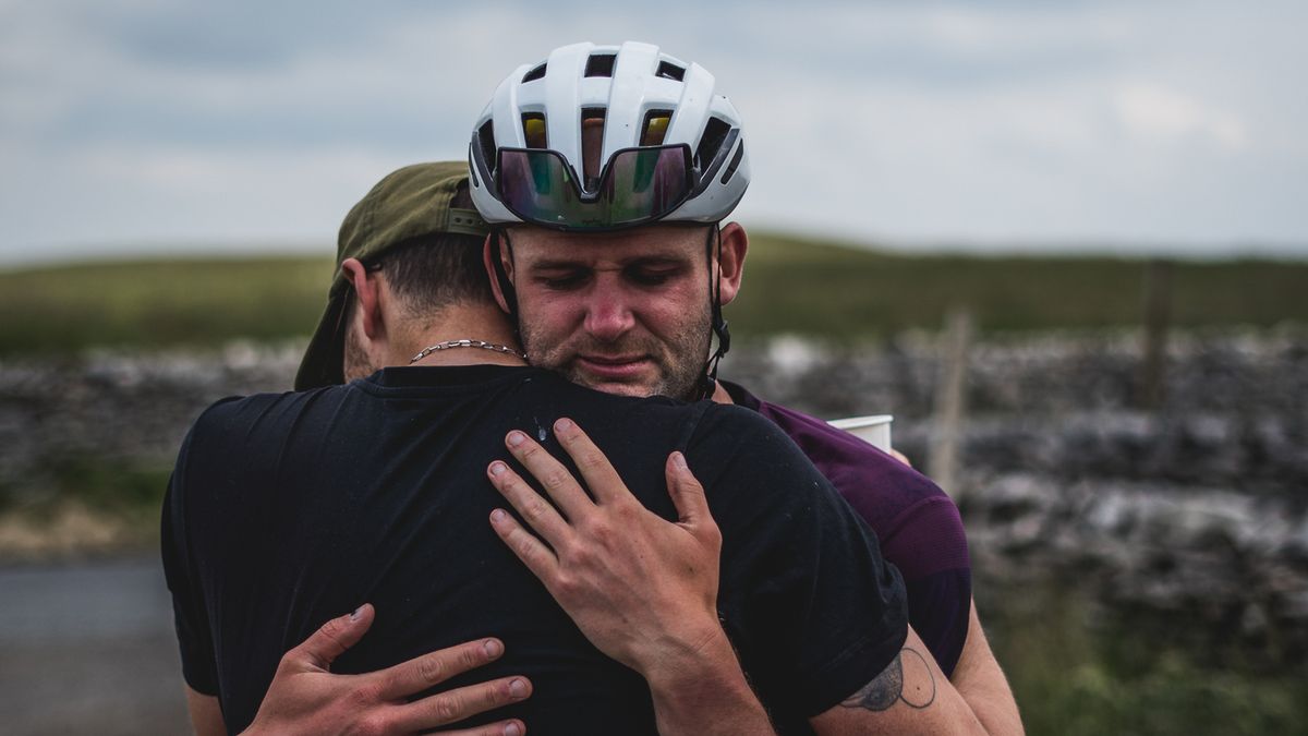 Two people embracing beside a road