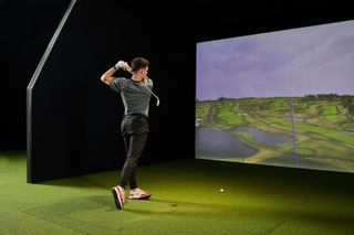 Golfer hits a shot in a trackman simulator