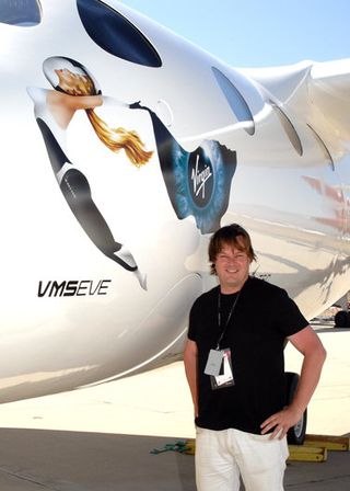Canadian John Criswick poses for a photo with Virgin Galactic's WhiteKnightTwo Eve, the carrier aircraft that will launch the SpaceShipTwo spaceliner into suborbital space during his spaceflight.