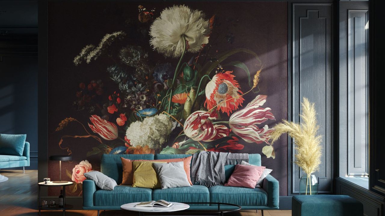 A large wall mural showing oversized flowers painted on a deep, dark background. Rich reds, creams and greens stand out against the darkness. The design feels dramatic and decorative, creating a bold focal point behind the seating area.