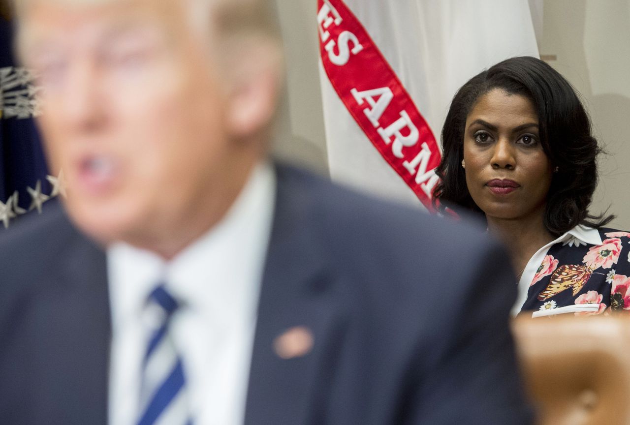 Omarosa Manigault Newman peers from behind President Trumps shoulder