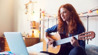 A woman learning guitar online