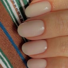 A creamy manicure against a stripey background