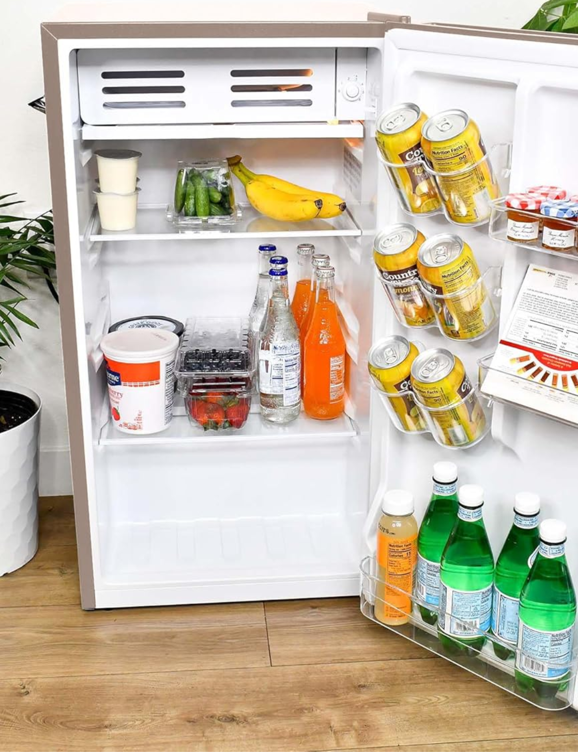 View of a Frigidaire mini fridge's inside organization, including two tiers for food, as well as several racks for beverages on the side