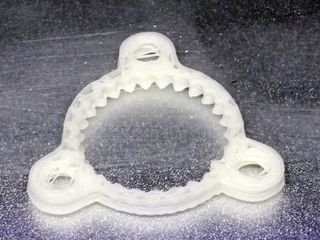 One of the few remotely successful prints. Note the stray filament in the holes and visible layering.