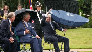 stafford, england july 28 prince charles, prince of wales looks on as c british prime minister, boris johnson r opens his umbrella at the national memorial arboretum on july 28, 2021 in stafford, england the police memorial, designed by walter jack, commemorates the courage and sacrifice of members of the uk police service who have dedicated their lives to protecting the public the memorial is set on grounds landscaped by charlotte rathbone within the national memorial arboretum and stands along with 350 memorials for the armed forces, civilian organisations and voluntary bodies who have played their part serving the country photo by christopher furlong wpa poolgetty images