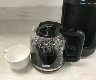 Bodum Bistro Programmable Coffee Maker carafe beside a cup of coffee
