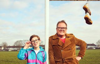 Alan Carr and Oliver Savell stand by a football goal in Changing Ends.
