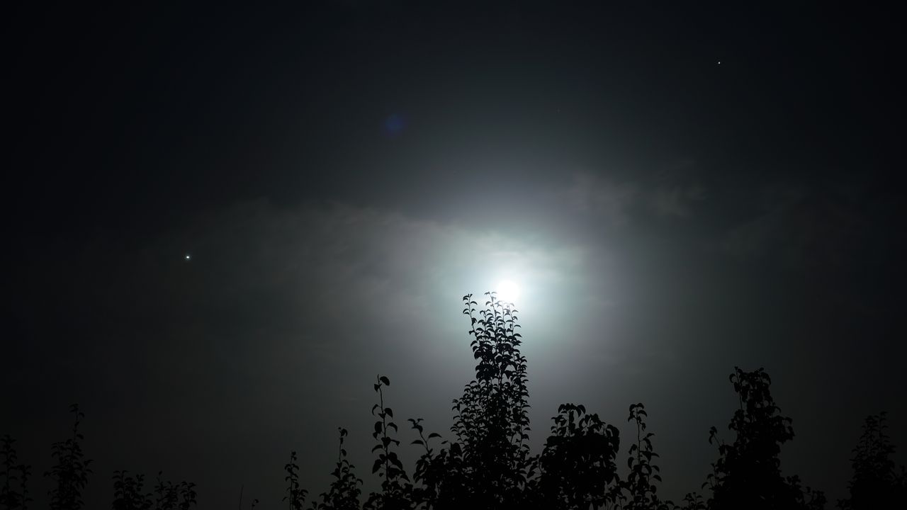 The moon rises with Saturn and Jupiter on Aug. 21, 2021 in Korla, China.