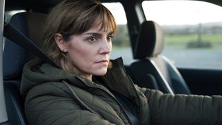 Annabel Scholey as Cathy looking pensively at the wheel of a car in Dead and Buried