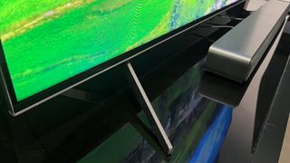 TCL Q7 stand with soundbar beside it