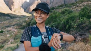 Female rock climber checking her smartwatch