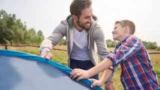 Why take kids camping? Man and his son pitching tent