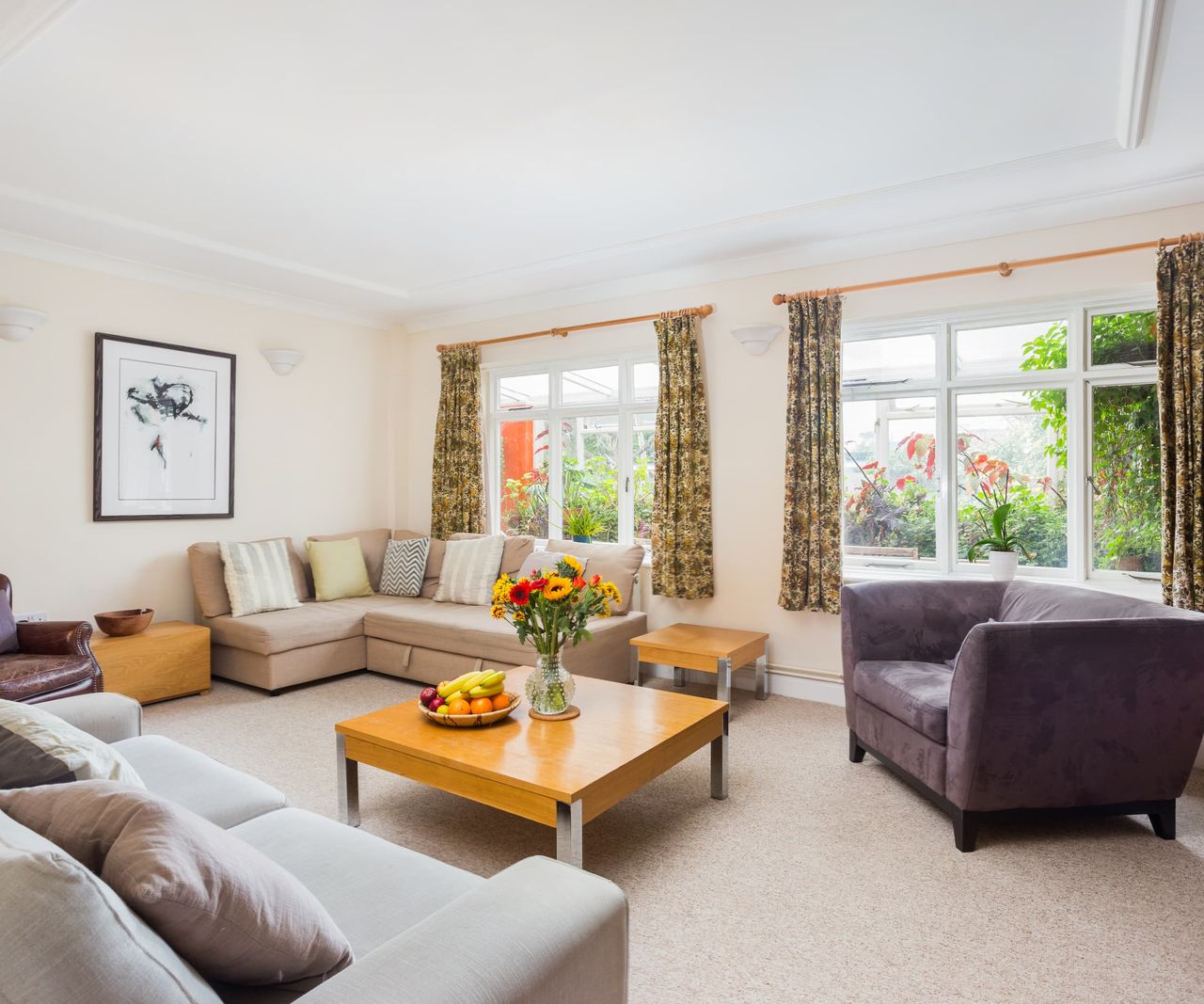 A living room with two windows with white carpet, walls and roof