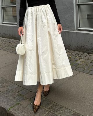 @annabelrosendahl wearing leopard-print heels with a skirt